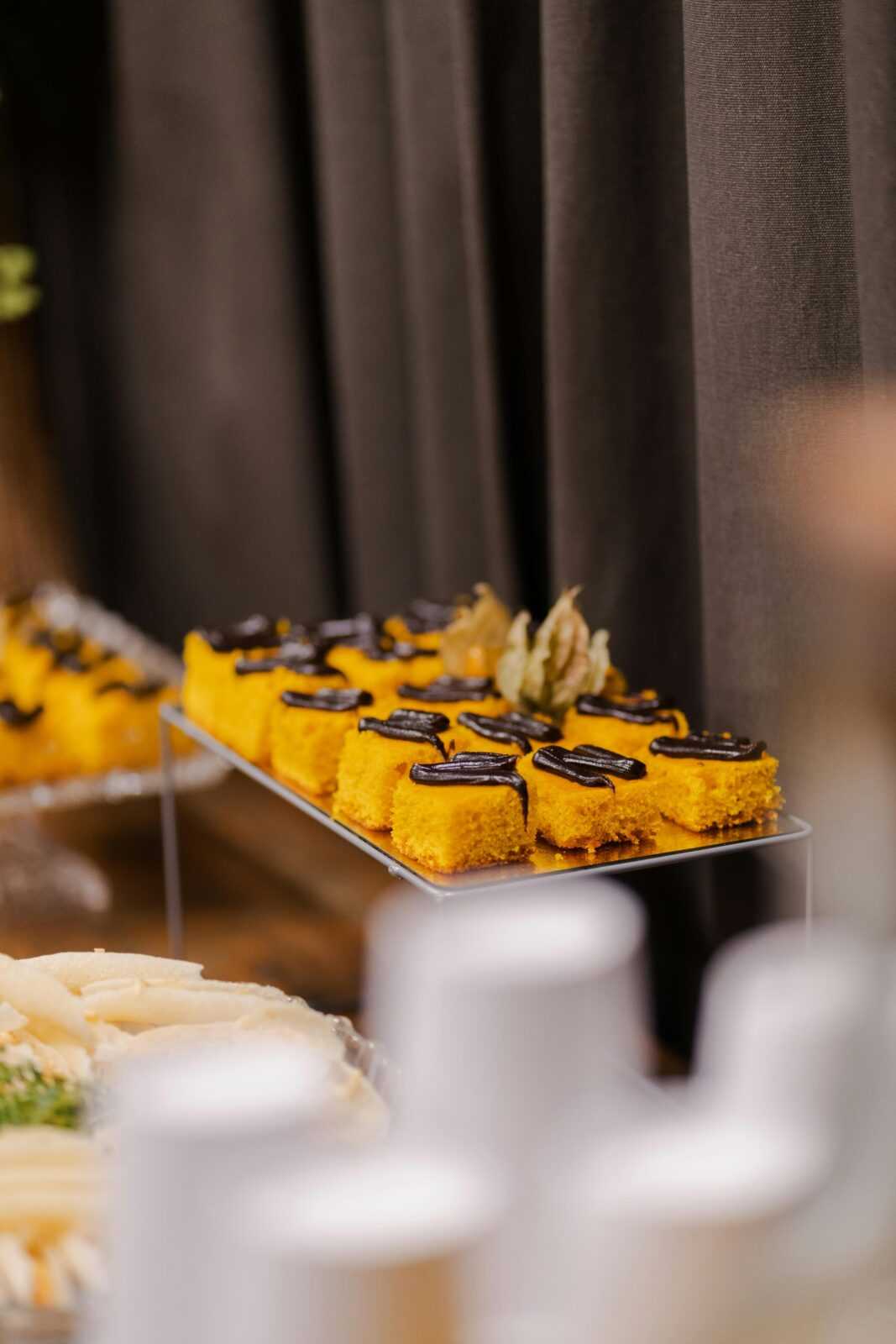 Indulge in these vibrant orange pastries topped with chocolate drizzle, perfect for elegant gatherings.